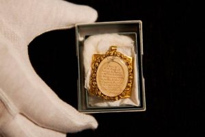 A lock of Wolfgang Amadeus Mozart's hair, contained in a 19th-century gilt locket is posed for photographs at the Sotheby's auction house in London, Tuesday, May 26, 2015.  The lock of hair is estimated to fetch 10,000 to 12,000 pounds ($15,383 to $18,459, euro14,109 to 16,931) as part of the Music, Continental and Russian Books and Manuscripts auction on Thursday May 28 in London.  (AP Photo/Matt Dunham)