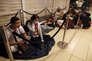 Nguyens rest as they queue to be the first for the launch of the new Apple iPhone 6s mobile phone at a mall in Singapore