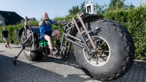 In this photo taken Saturday, Aug. 27, 2016 Frank Dose for the first time rides his self made bicycle in Rade, Germany. With giant tires from an industrial fertilizer spreader and scrap steel, a Dose has built a bike weighing 940 kilograms (2,072 pound) that he plans to pedal into the record books as the world’s heaviest rideable bicycle. (Markus Scholz/dpa via AP)